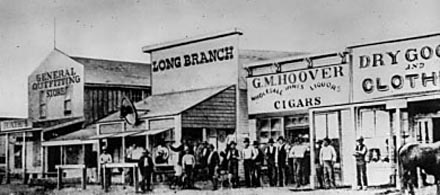 [photo: The 1874 view of Front Street, with (from left)Rath and Wright's General Outfitting Store, Beeson and Harris' Long Branch, and Hoover's cigar and liquor store. All rights reserved, FCHS.]