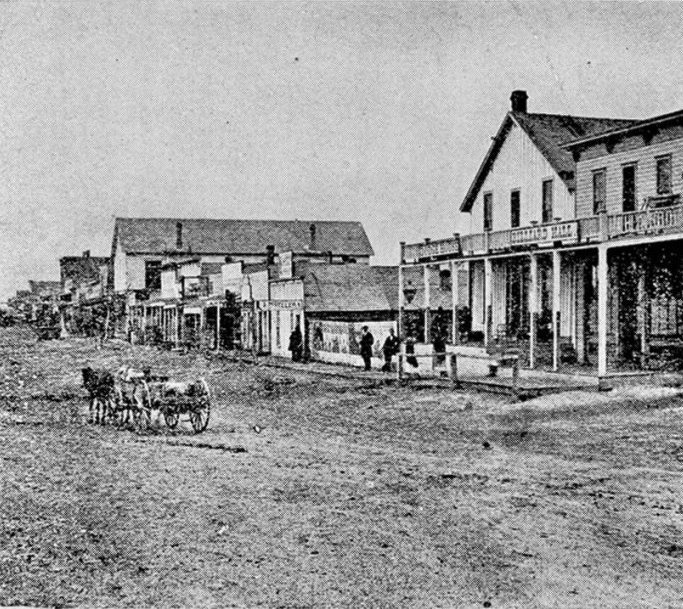 [Another view of Dodge City in 1879. This appears to be some of the buildings further along Front Street. They are, for the most part, less substantial than those in the view facing page 48, and lack the raised walk to accommodate teams and wagons. ]