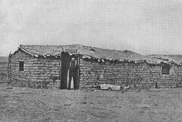 [photograph: Henry Sitler's sod-house along Santa Fe Trail, the first building on future location of Dodge City. Sitler not person in door.]